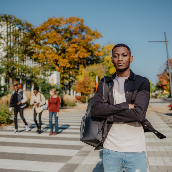 Étudiant posant sur l'allée piétonnière