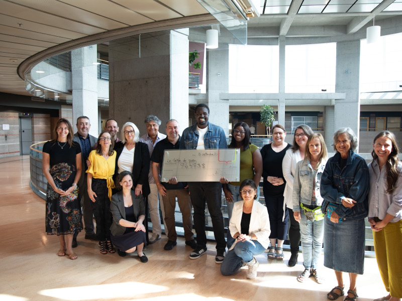 Remise de chèque au président de la Table du Pain, Giresse Mpey Ilimi, en compagnie de l'équipe du Centre d'appel de la DPRD